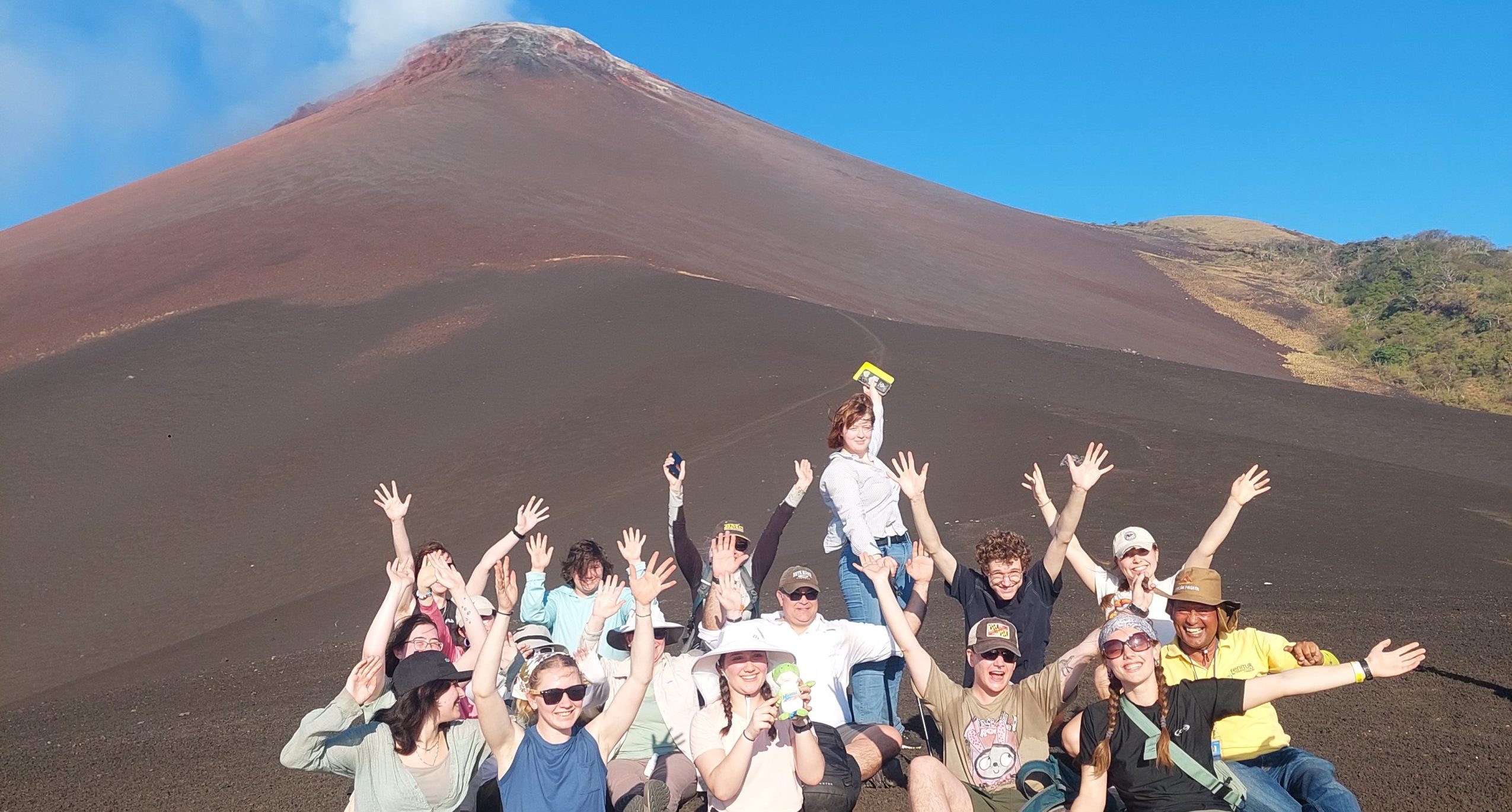 Hikers enjoying spectacular panoramic views on Momotombo volcano with brown cone fully visible