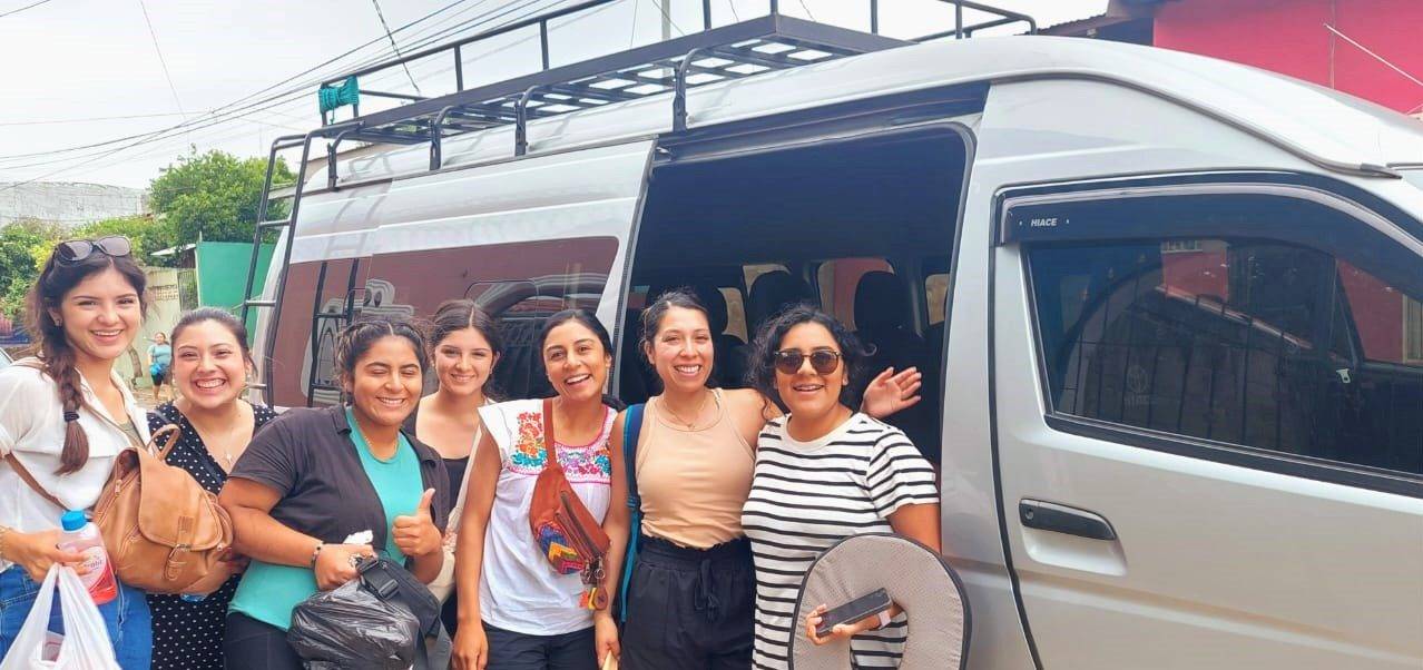 group of travelers standing beside a modern van in icaraguaN